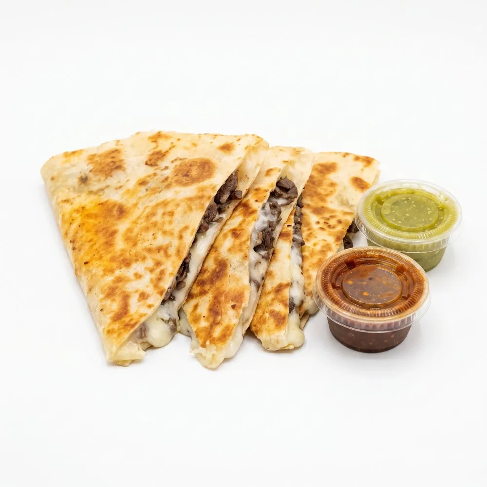 Steak quesadilla cut in wedges with green and red salsa cups